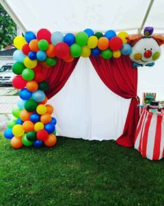 DRAPED BACKDROP WITH THEMED BALLOON GARLAND