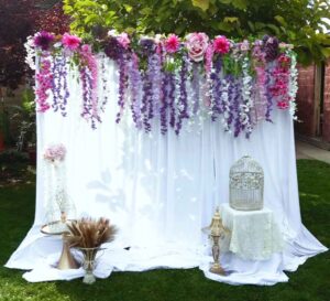 DRAPED BACKDROP WITH ARTIFICIAL WISTERIA FLORAL VALANCE AND VINTAGE DETAILS