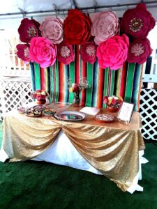 MEXICAN SERAPE BACKDROP WITH HANDMADE PAPER FLOWERS AND TABLE SETUP WITH SERVEWARE AND TABLE DECOR