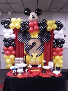 THEMED BALLOON BACKDROP WITH HANDMADE THEMED DETAILING AND TABLE SETUP WITH SERVEWARE AND TABLE DECOR